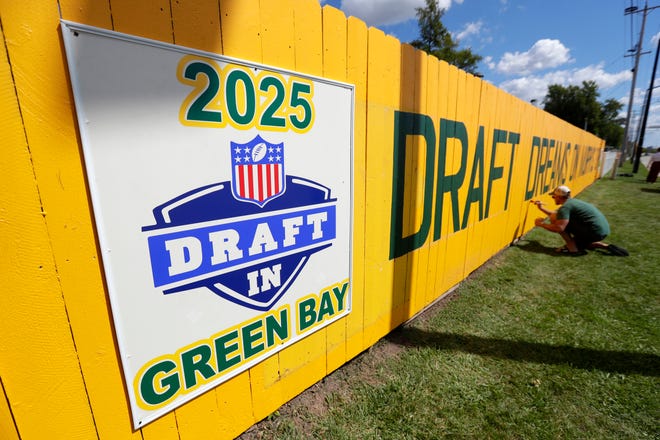 Matt Pecard of Green Bay touches up the newly painted Packers fence at 1177 Shadow Lane on Sept. 2 in Green Bay. The original Packers fence is 40 years old.