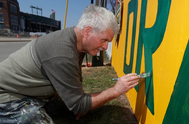 Christopher Handler paints the fence at 1167 Shadow Lane on April 11, 2025, in Green Bay, Wis., celebrating the 2025 NFL Draft at Lambeau Field.