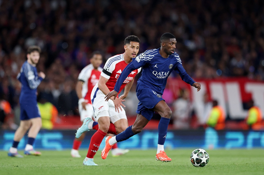 LONDON, ENGLAND: Ousmane Dembele of Paris Saint-Germain runs with the ball whilst under pressure from William Saliba of Arsenal during the UEFA Champions League 2024/25 Semi Final First Leg match between Arsenal FC and Paris Saint-Germain at Emirates Stadium on April 29, 2025. (Photo by Michael Steele/Getty Images)