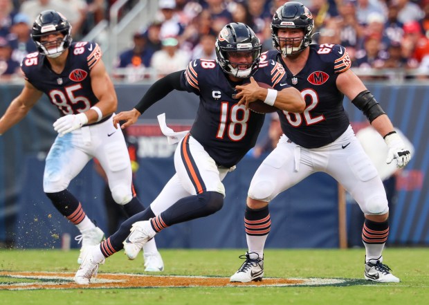 Bears quarterback Caleb Williams carries the ball in the fourth...